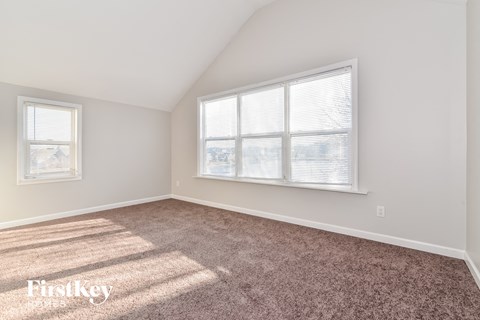a bedroom with carpet and a large window