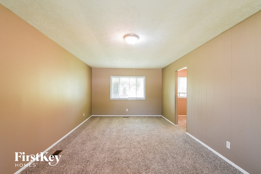 A room with a carpeted floor and a window.