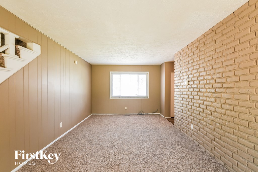A room with a brick wall and a window.