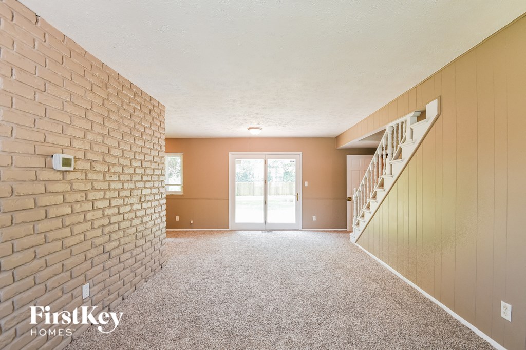 A room with a brick wall and a staircase.