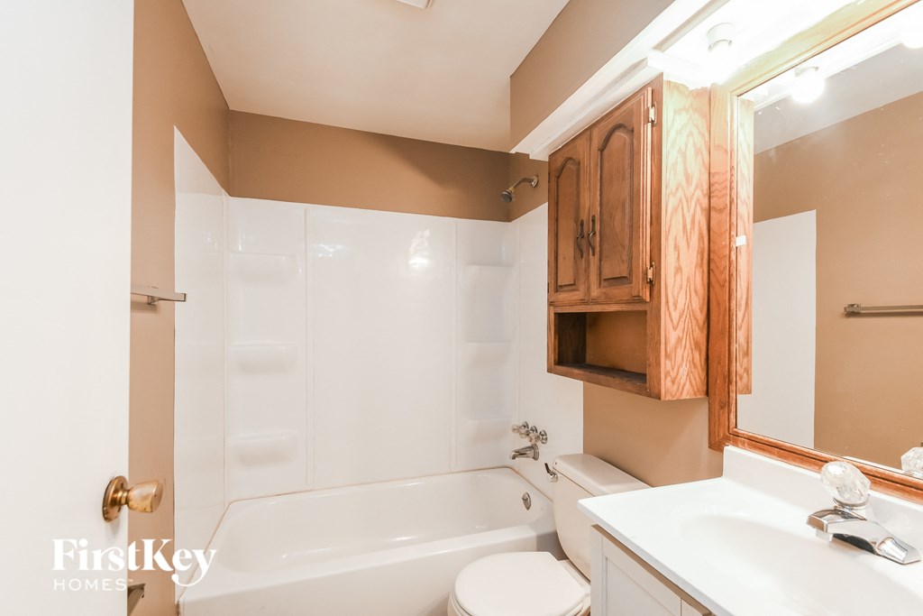 A bathroom with a tub, toilet, and sink.