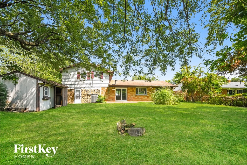 A house with a lawn and trees in the background.