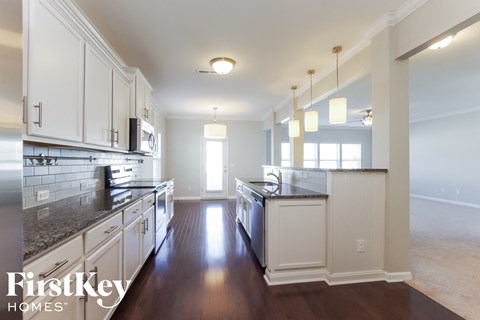a large kitchen with white cabinets and granite counter tops