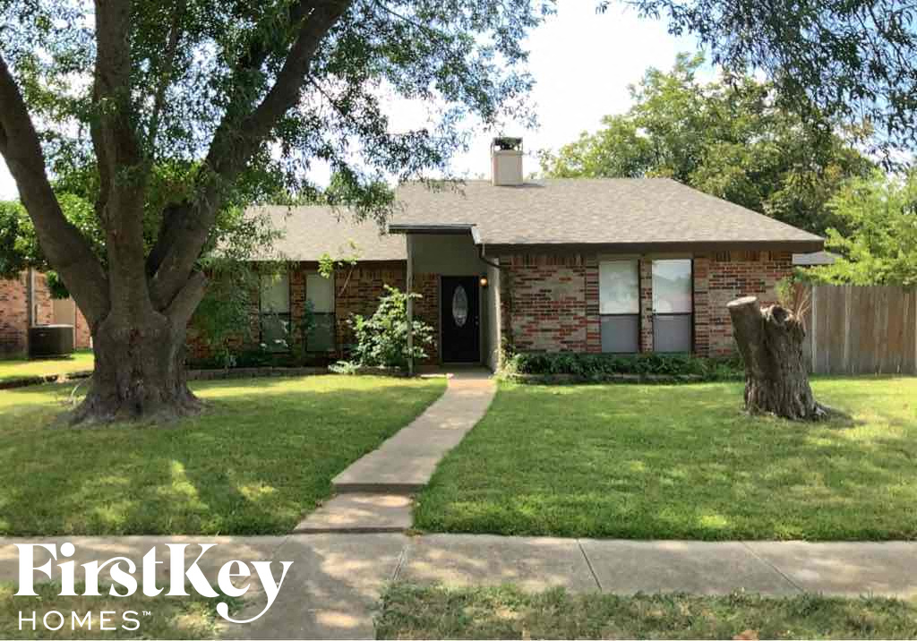 a small brick house with a tree in the yard