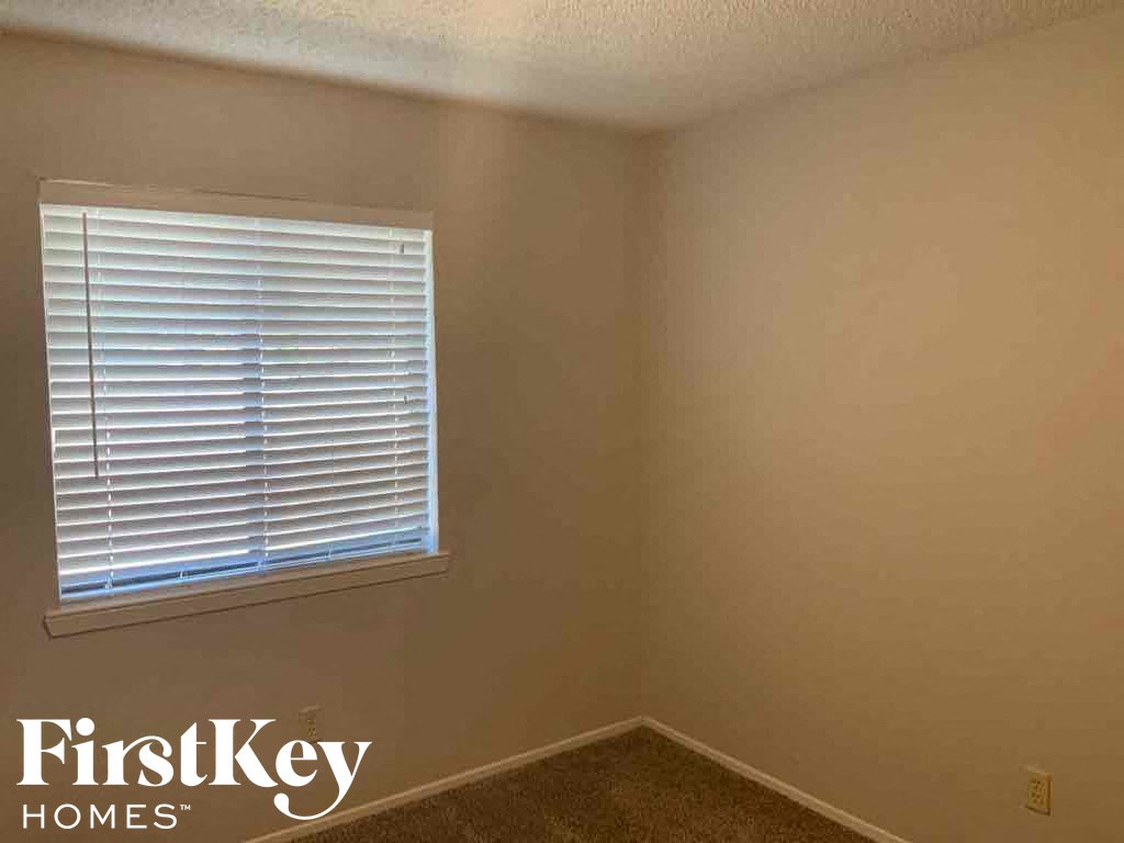 a small room with a window and a beige wall