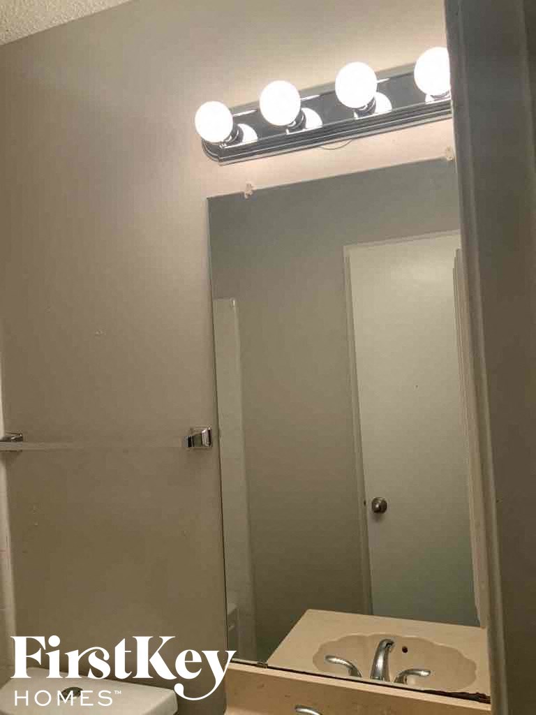 a bathroom with a sink and a mirror and lights on the ceiling