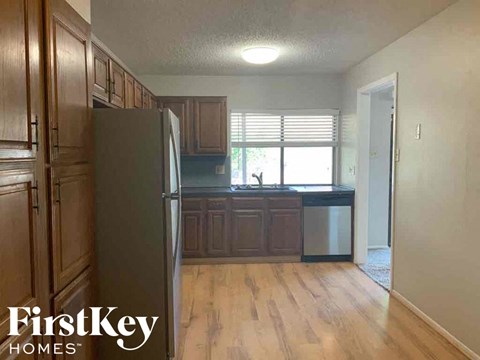 a kitchen with wooden floors and a refrigerator