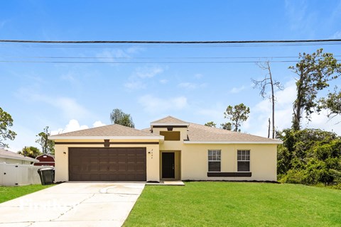 the front of a house with a driveway and a garage door