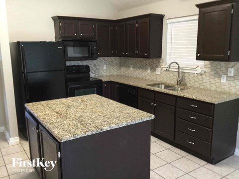 a kitchen with black cabinets and granite counter tops