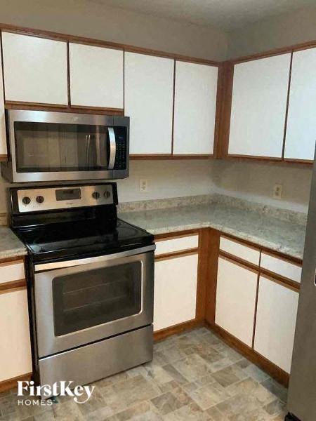 A kitchen with a stove and oven, and cabinets.
