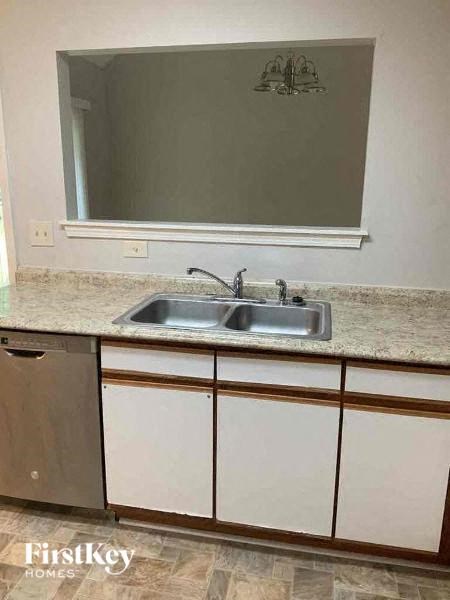A kitchen with a sink and a mirror above it.