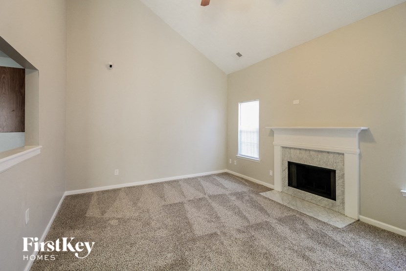 A room with a fireplace and a carpet on the floor.