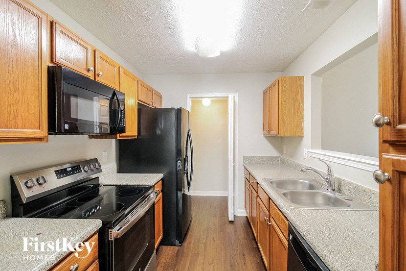 A kitchen with wooden cabinets and black appliances.