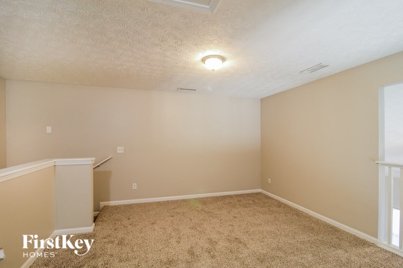 A carpeted room with a FirstKey Homes logo on the bottom left.