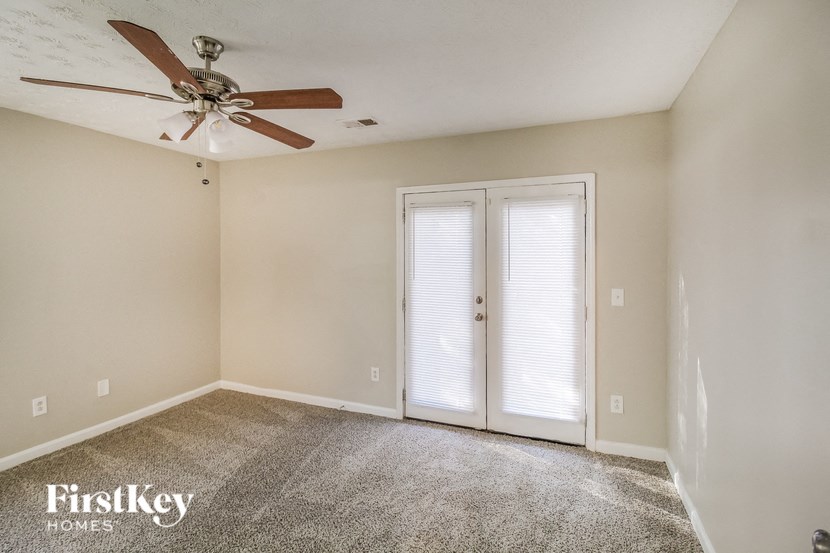 A room with a ceiling fan and a carpeted floor.