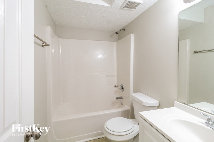 A white bathroom with a toilet, sink, and bathtub.
