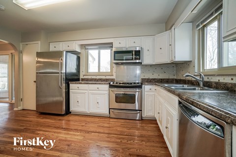 A kitchen with wooden floors and stainless steel appliances.