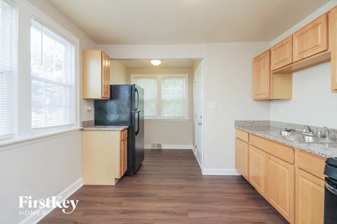 a kitchen with wooden cabinets and a black refrigerator