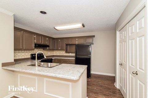 A kitchen with a white counter top and brown cabinets.
