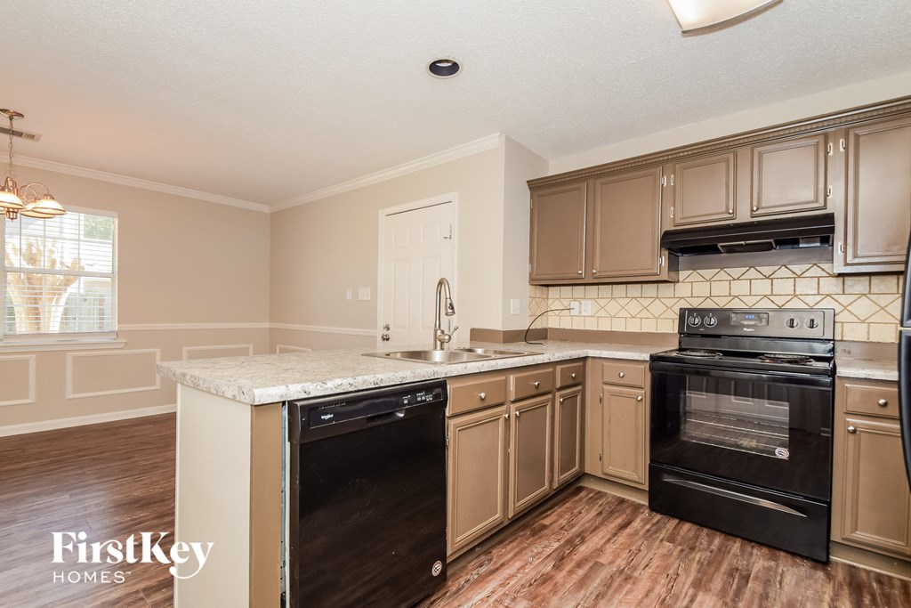 A kitchen with wooden cabinets and black appliances.