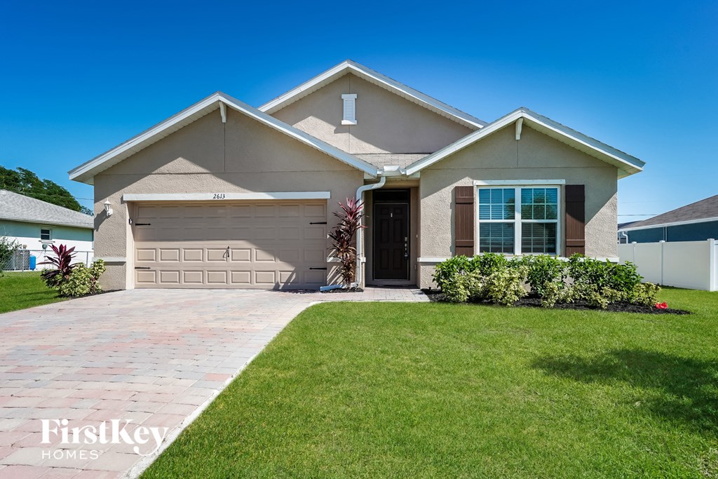 A house with a garage and a driveway in front.