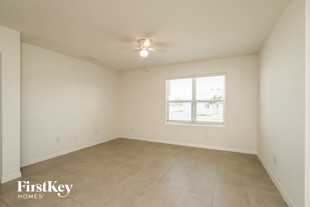 A spacious room with a window and tiled floor.