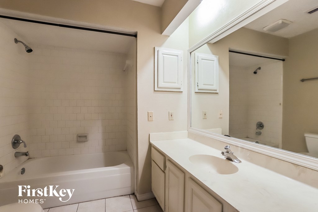 a bathroom with a sink and a tub and a mirror