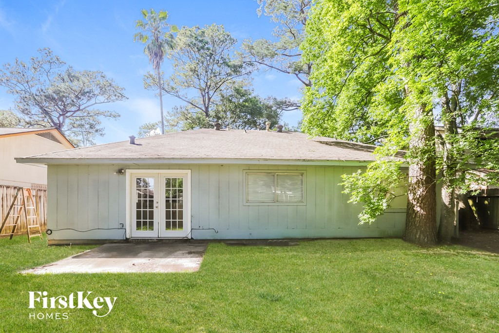 a small white house with a yard and trees