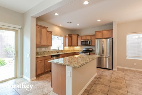 A kitchen with a granite counter top and stainless steel appliances.