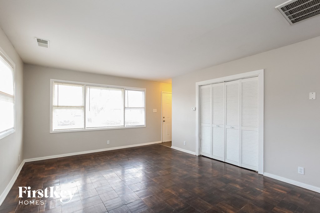 an empty living room with wood floors and a large window