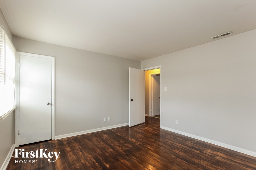 an empty living room with wood flooring and white walls