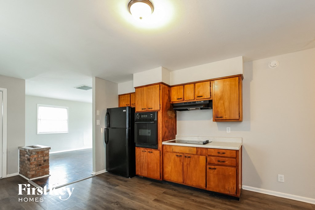 a kitchen with wooden cabinets and a black refrigerator