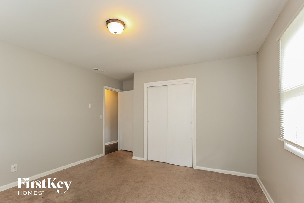 a master bedroom with a closet and a door to a bathroom