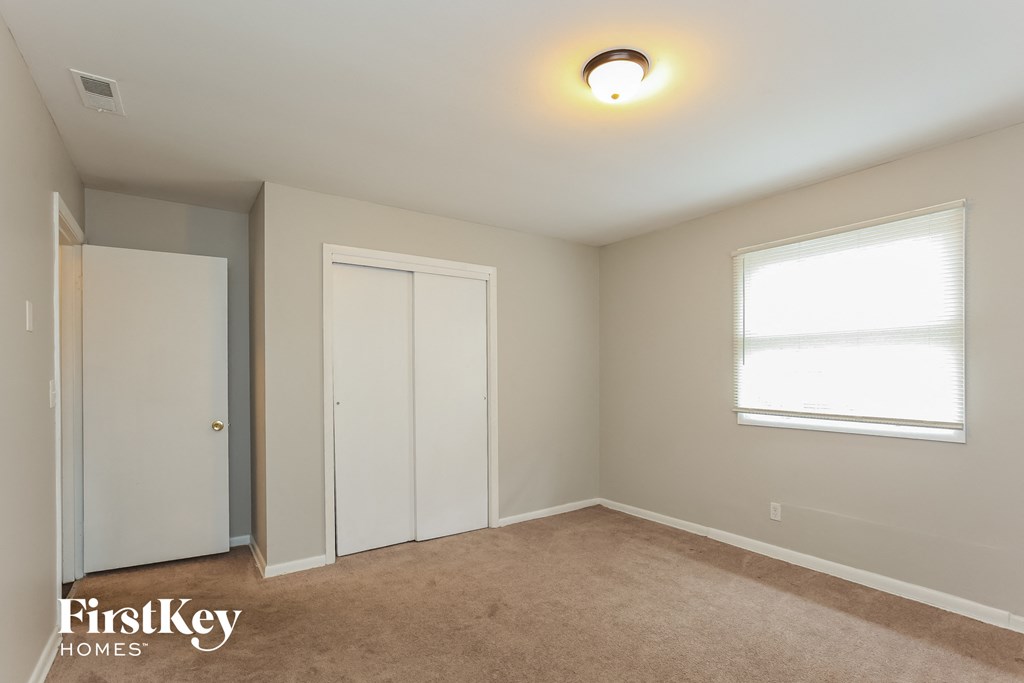 a bedroom with a closet and a window and a door