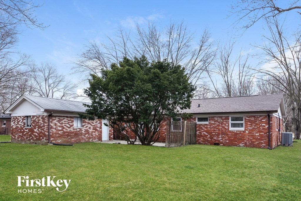 a brick house with a tree in the yard