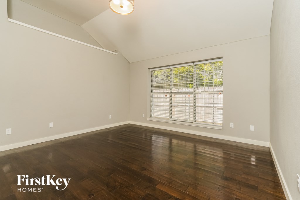 the living room with wood floors and a large window