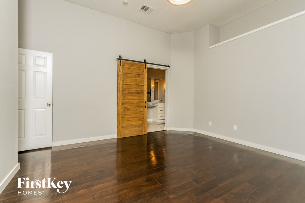 the living room with wood floors and a sliding door to the bathroom