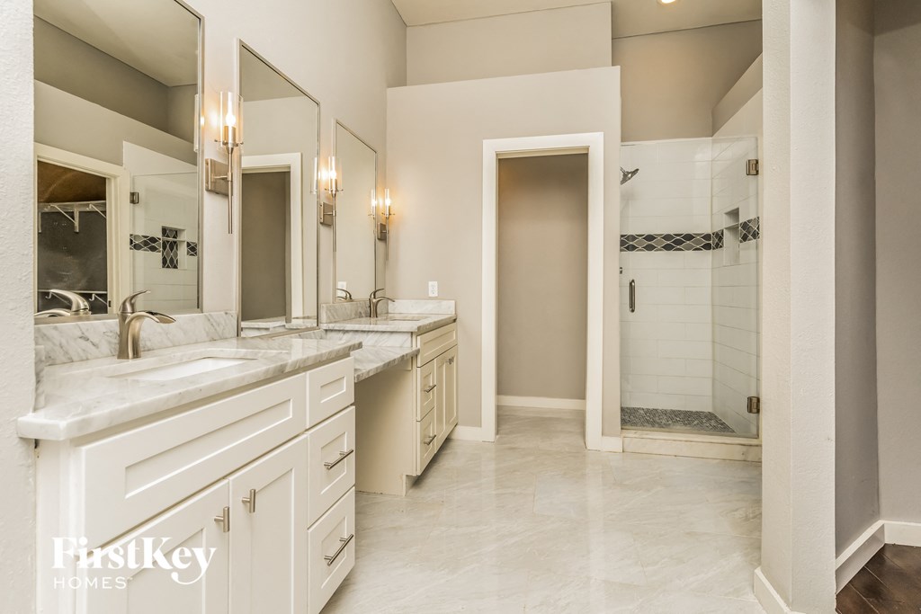 a large white bathroom with two sinks and a shower