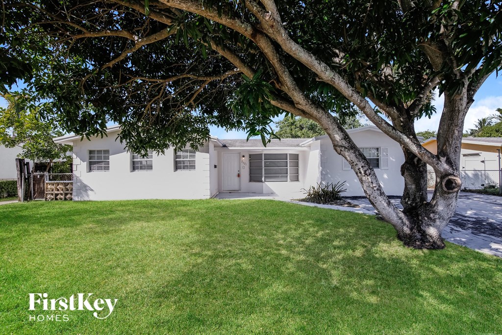 a white house with a tree in the yard