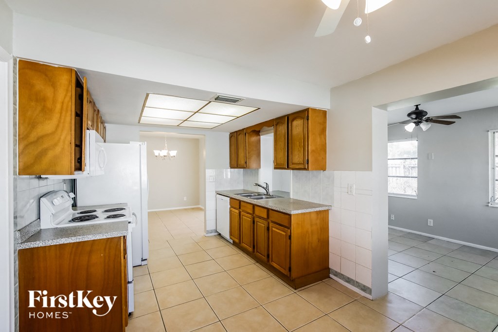a kitchen with white appliances and wooden cabinets