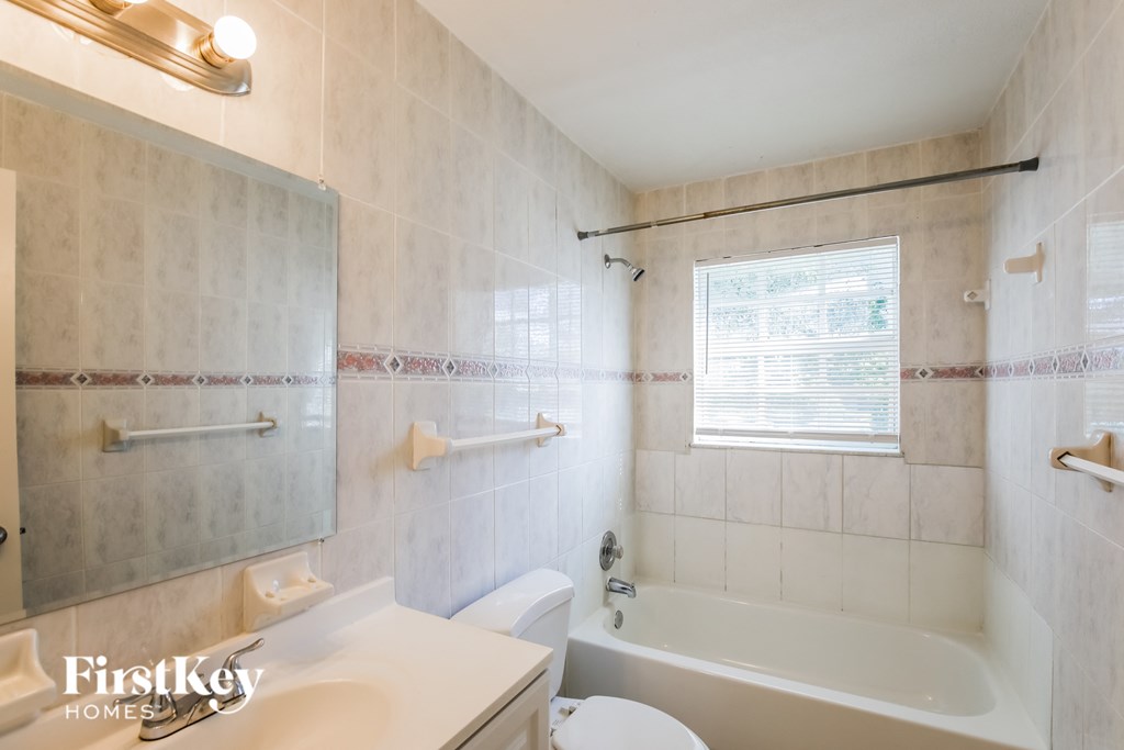 a white bathroom with a tub and a sink and a toilet