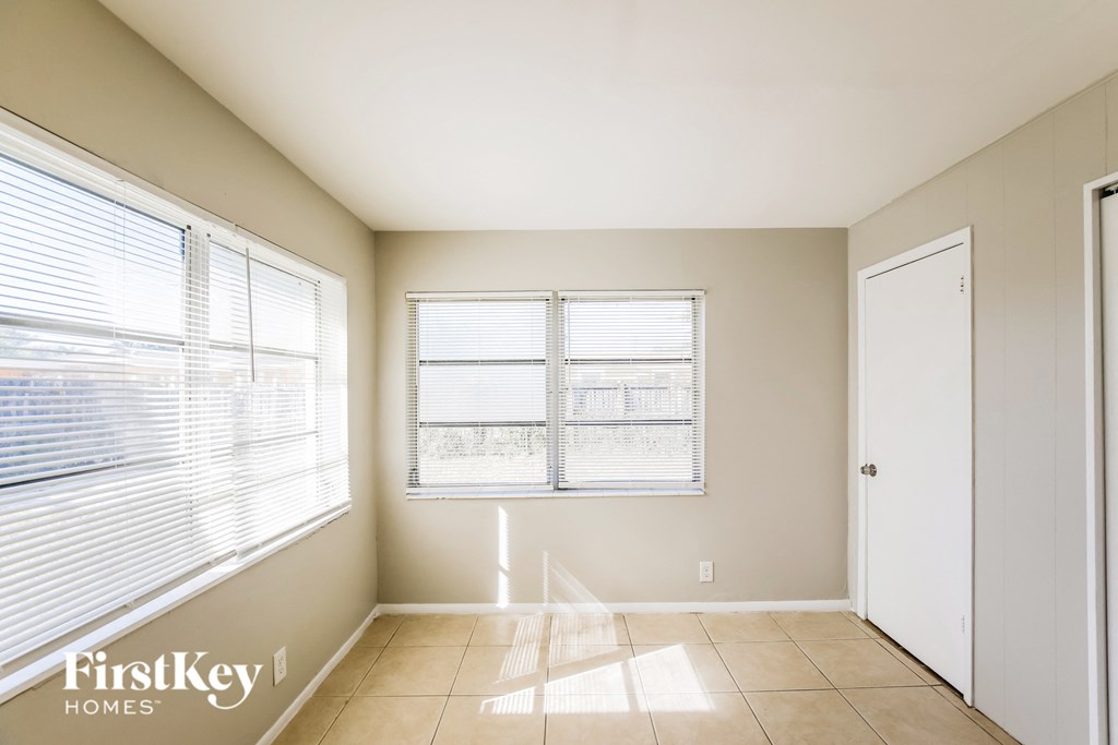 a room with two windows and a door and a tiled floor