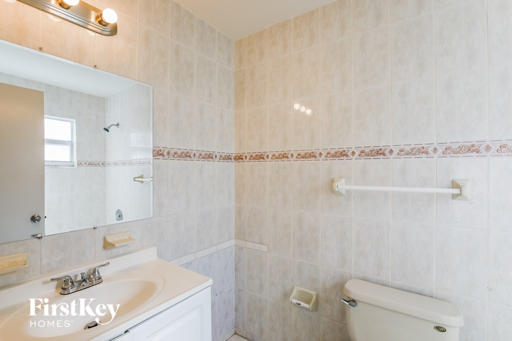 a bathroom with a toilet and a sink and a mirror