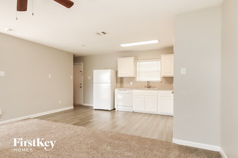 A spacious kitchen with white appliances and cabinets.