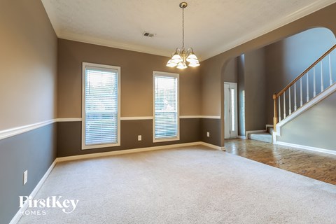 an empty living room with a staircase and window