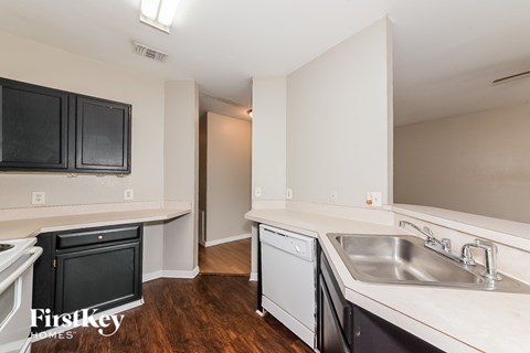 A kitchen with black cabinets and a white counter top.