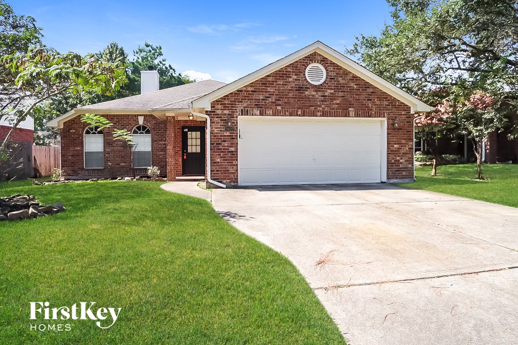 A brick house with a garage door is for sale.