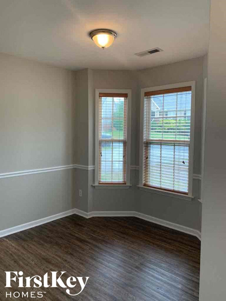 A room with wooden floors and two windows.