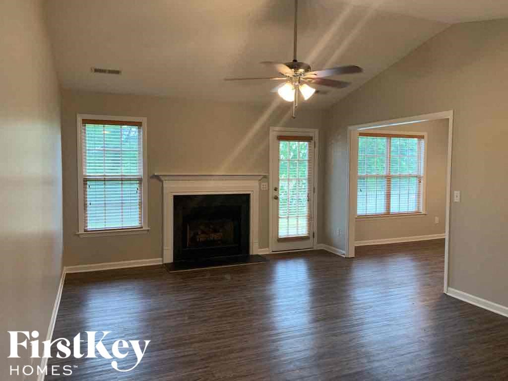 A living room with a fireplace and a ceiling fan.