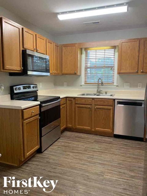 A kitchen with wooden cabinets and a stainless steel dishwasher.